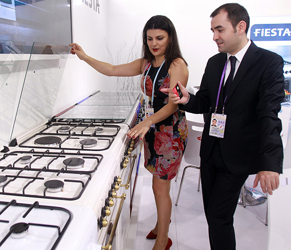 A Kent-Fiesta Ltd representative (left) introduces the Fiesta-branded gas stoves to a potential buyer at the ongoing Canton Fair in Guangzhou. (Photo/China Daily)