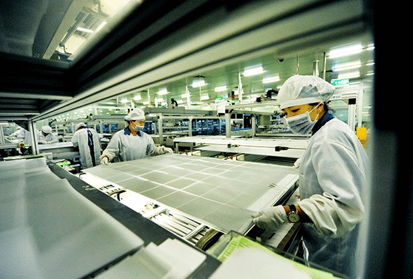 Workers at a plant of JinkoSolar in Jiangxi province produce solar polycrystalline silicon sheets.(ZHUO ZHONGWEI/CHINA DAILY)