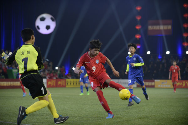 Afeirtin, a primary school student from Xinjiang Uygur autonomous region, scores a goal at final of the Who's the King National grassroots soccer. (For chinadaily.com.cn)