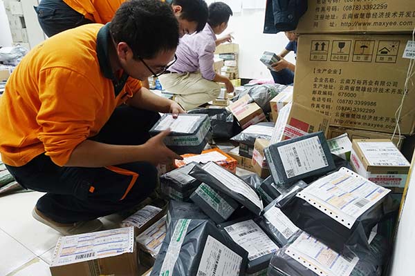Workers at a local express company in Fuyang, Anhui province, sort packages for delivery. WANG BIAO/CHINA DAILY