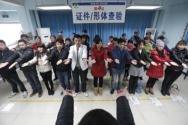 Job seekers undergo a physical check at an Apple Inc's original equipment manufacturer in Wuhan, Hubei province. Many factories in China are OEMs for Apple to produce iPhones and iPads. (Photo provided to China Daily)