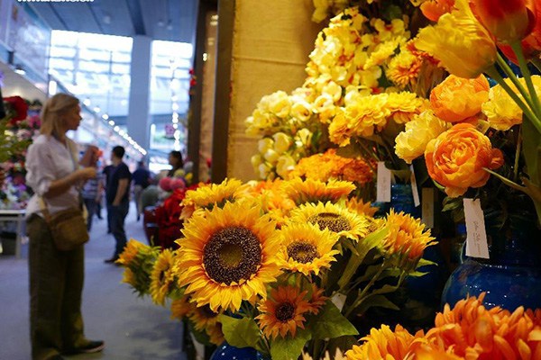 A woman views artificial flowers during the China Import and Export Fair, or the Canton Fair, in Guangzhou, capital of South China's Guangdong province, Oct 26, 2015. (Photo/Xinhua)