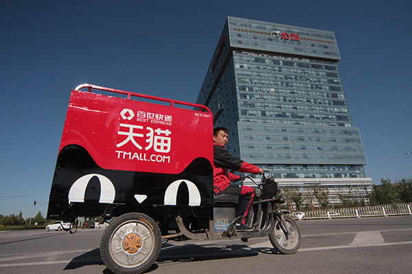 A delivery agent rides past the headquarters of e-commerce company JD.com Inc in Beijing. (Photo/China Daily)