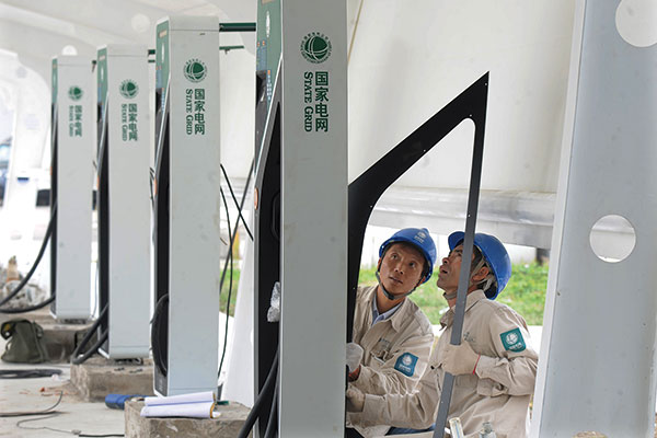 Engineers for the State Grid Corp of China install vehicle charging facilities in Yangzhou, Jiangsu province. The central government has vowed to provide sufficient charging infrastructure for new-energy vehicles. (Photo/Xinhua)