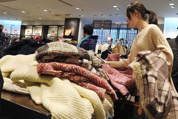 A shopper looks at items at a Zara store in Shanghai. Foreign brands are seeking to lure more youngcustomers by offering stylish designs at cheaper prices in China. (Photo provided to China Daily)