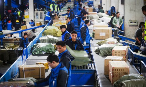Employees from ZTO Express's Shanghai center work overtime to sort packages early Wednesday morning. The number of packages received by ZTO Express increased threefold on Wednesday due to the Singles' Day online shopping spree. (Photo: Yang Hui/GT)