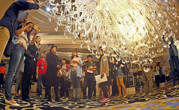 Visitors take a look at a lighting products made by Zhongshan Kinglong Lighting Co Ltd in Guzhen township, Guangdong province, Nov 11, 2015. (Photo by Li Baojun for chinadaily.com.cn)