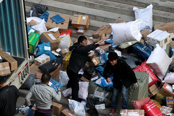 Deliverymen sort packages at the front gate of a logistics company on Nov 3 in Zhengzhou, Henan province. The Chinese delivery industry had revenues of 204 billion yuan ($32 billion) in 2014, up 42 percent year-on-year. (Photo/China Daily)