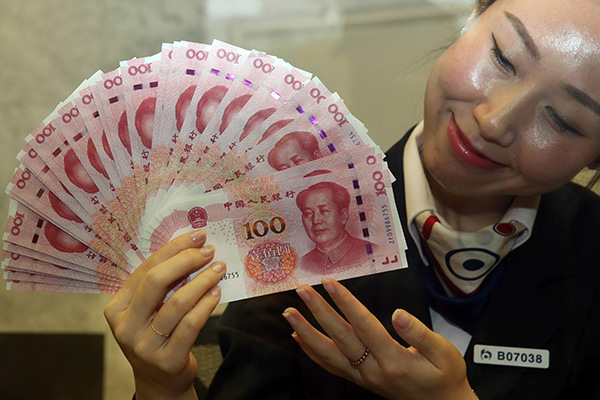 The latest edition of the 100-yuan bank note is displayed at a local branch of Bank of Communications in Beijing on Nov 12, the day it was issued. (Photo/China Daily)