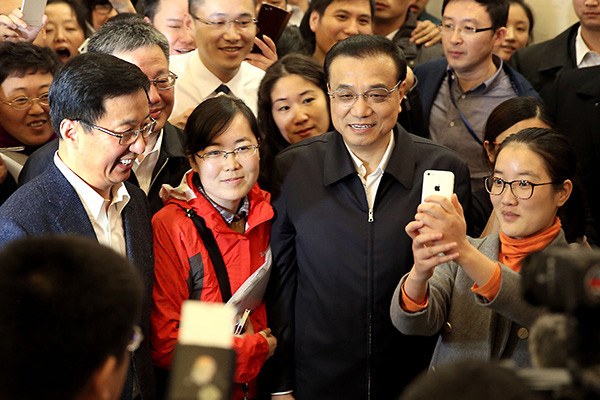 Premier Li Keqiang is in high demand for selfies during his visit to the Shanghai free trade zone on Nov 25, 2015. (Photo/China Daily)