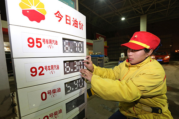An employee at a PetroChina Co Ltd gas station in Nanjing, capital of Jiangsu province, alters oil prices. (Photo/China Daily)