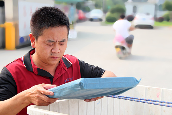 A Shanghai YTO employee checks a parcel's address to make sure it is correct. (Photo provided to China Daily)