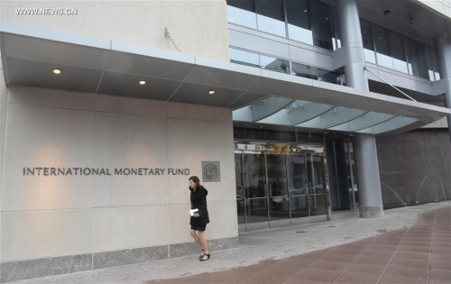 Photo taken on Nov. 30, 2015 shows a woman walking past the headquarters of the International Monetary Fund (IMF) in Washington D.C., the United States. (Photo: Xinhua/Bao Dandan)