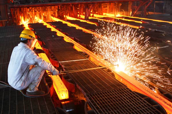  worker cuts steel bars on the production line of a mill in Lianyungang, Jiangsu province. (Si Wei / For China Daily)