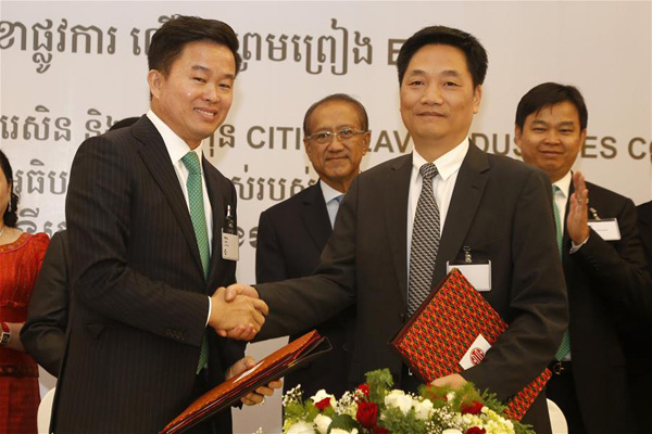 Yu Zhangfa (R), CITIC Heavy Industries Company CEO, shakes hands with Leang Meng, chief executive of Chip Mong Group, during a signing ceremony in Phnom Penh, Cambodia, Dec. 5, 2015. China's leading cement equipment manufacturer and service provider CITIC Heavy Industries Company on Saturday secured an engineering, procurement and construction (EPC) contract from a Cambodian conglomerate to build a 262 million-U.S.-dollar cement plant in Cambodia. (Xinhua/Phearum)
