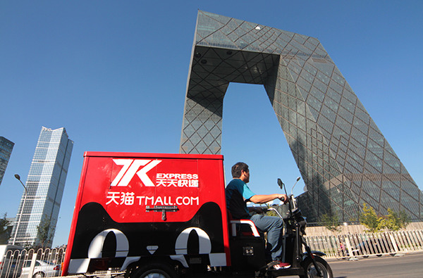 A delivery cart with the logo of Tmall.com, Alibaba's B2C platform, passes the CCTV building in Beijing. (Wu Changqing/China Daily)