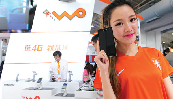  model stands next to promotional material on China Unicom's 4G services at an industry expo in Beijing. (Photo/China Daily)