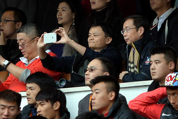 Jack Ma, executive chairman of Alibaba Group Holding Ltd, takes snapshots during a soccer tournament that Guangzhou Evergrande took part in earlier this year. (Photo provided to China Daily)