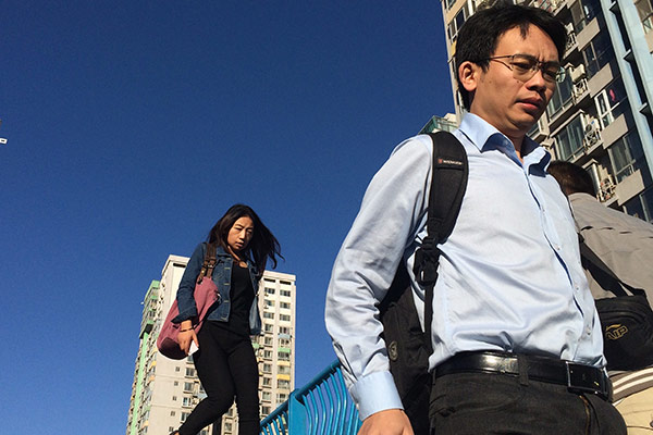  office workers walk past an overpass in Beijing. For young people, living in big cities such as Beijing means better lifestyle and greater chance of success.(BAI JIKAI/FOR CHINA DAILY)