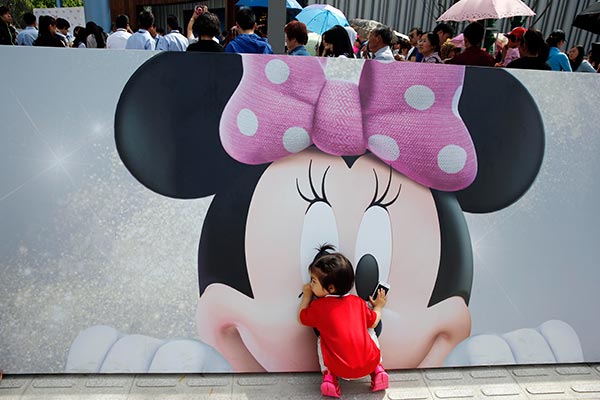 A girl touches a Minnie Mouse cartoon at the Disney's flagship store in Shanghai. (YIN LIQIN/FOR CHINA DAILY)