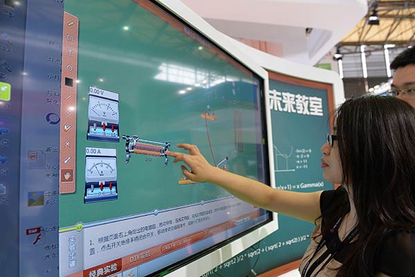 A visitor tries out a touch blackboard with 5G technology at a recent industry expo in Shanghai.(Photo/Xinhua)