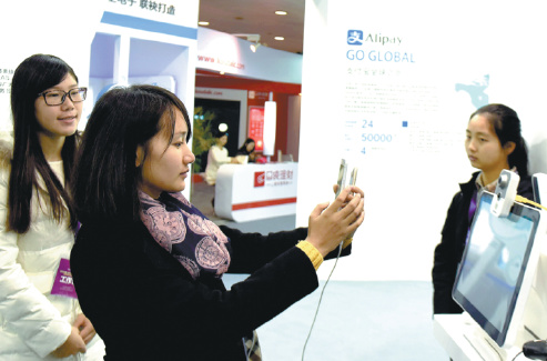 A visitor tries face-identification technology at the booth of Ant Financial, Alibaba's finance affiliate, during an industry expo in Hangzhou, capital of Zhejiang province. (LONG WEI/FOR CHINA DAILY)