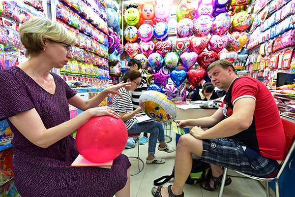 Two Russian buyers choose balloons at Yiwu Small Commodities Market in Zhejiang province. (Photo/China Daily)