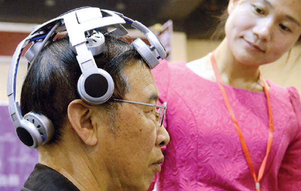 A man tests a brain disease treatment device at an international expo for the industry for seniors in Zhengzhou, capital of Henan province. The country faces an unprecedented challenge, with about 212 million aged 60 years or above.(Photo/China Daily)