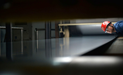 A technician checks steel plates at a Han-Steel Co Ltd unit in Handan, Hebei province.Photo: Hao Qunying/For China Daily)