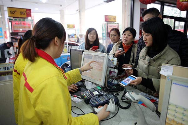 People enjoy a 85 percent discount by paying for their vehicle fuel with Alipay Wallets at a gas station in Shaoxing, Zhejiang province.Photo/China Daily