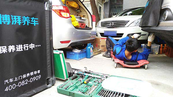 An engineer for Bopai (Beijing) Automotive Technology Service, which recently closed its office in the Chinese capital, repairs a car in July. (Provided to China Daily)