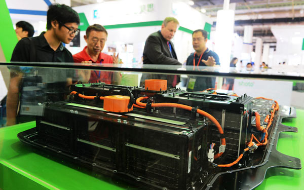 Visitors to an international battery expo in Beijing examine a new-energy vehicle battery. Market insiders warn plans need to be made for the safe disposal of such batteries in China. (Photo/China Daily)