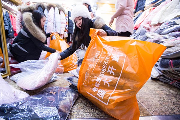 Taobao shop owners are busy packing clothes for their online customers from across the world.(Provided to China Daily)