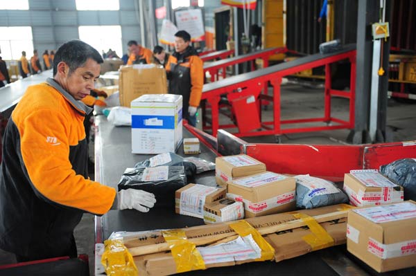 Workers sort parcels at a delivery company in Fuyang, Anhui province.(Photo/China Daily)