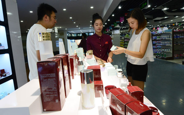 A customer buys imported cosmetics at a cross-border e-commerce experience center in Zhengzhou, Henan province.(Photo/China Daily)