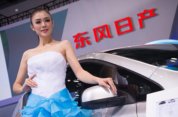 A model stands next to an energy-saving car at an auto expo in Beijing.(Photo: China Daily/Shu Hua)