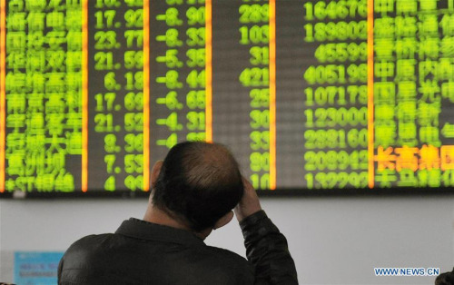 An investor looks through stock information at a trading hall in a securities firm in Hangzhou, capital of east China's Zhejiang Province, Jan. 7, 2016. (Photo/Xinhua)
