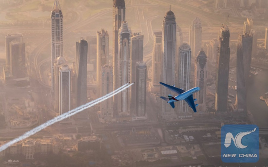 This photo released by Emirates Airlines on Nov. 5, 2015 shows people equipped with jet wings flying with an Airbus A380 aircraft over the sky of Dubai, United Arab Emarites. (Photo: Xinhua)