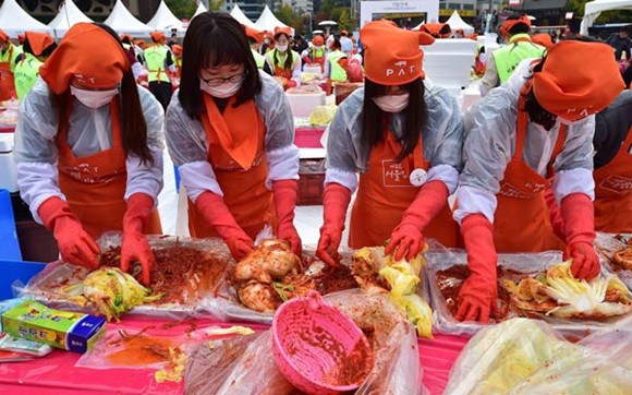 Participants take part in a kimchi making event during the Seoul Kimchi Festival outside the city hall in Seoul.Photo/China Daily
