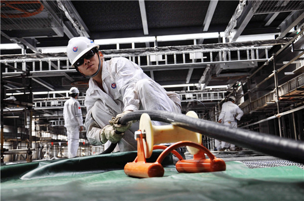 CNOOC Ltd workers install cables at an ocean oil project construction site near Qingdao, Shandong province.(Provided to China Daily)