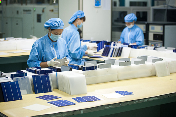 Technicians test solar panels at a workshop of Yingli Green Energy Holding Co in Shijiazhuang, Hebei province. (Photo/Xinhua)