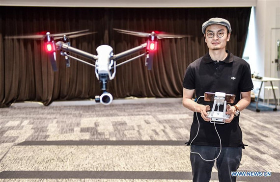 Wang Tao, founder of Da-Jiang Innovations (DJI), controls a drone in his company in Shenzhen, South China's Guangdong province, May 22, 2015. [Photo/Xinhua]