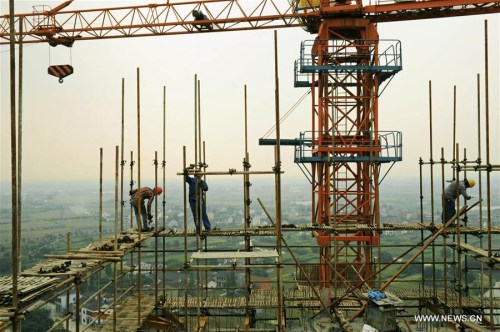 Photo taken on May 24, 2015 shows builders working at a construction site in the Nanxun District of Huzhou City, east China's Zhejiang Province. (Photo: Xinhua/Tan Jin)