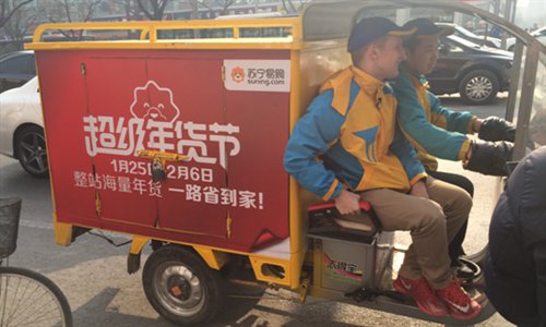 Samuel Keith, a student from the US, delivers packages with his colleague on Thursday in Beijing. (Photo courtesy of Suning Commerce Group)