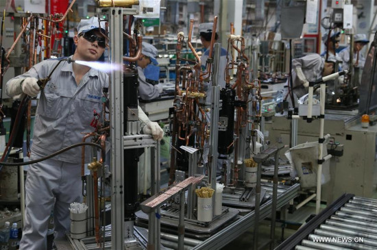 Workers are occupied on a production line at a factory in Xinzhuang industry zone in Shanghai, east China, July 30, 2015. (Photo: Xinhua/Pei Xin)