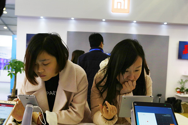 Visitors try the latest smartphones of Xiaomi Corp at an industry expo in Wuzhen, Zhejiang province. Photo/China Daily