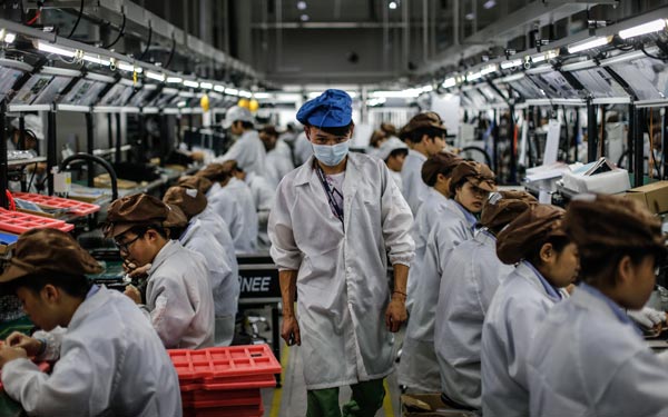 Workers at an export-oriented mobile phone parts enterprise in Dongguan, Guangdong province. (Photo/China Daily)
