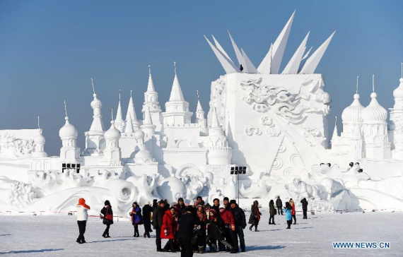 Tourists pose for photos in front of a snow sculpture at the Sun Island International Snow Sculpture Art Expo in Harbin, capital of northeast China's Heilongjiang Province, Jan. 31, 2015. (Photo: Xinhua/Wang Jianwei)
