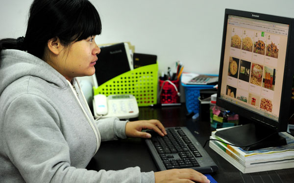 Tang Qiaoqing, a worker at the Wangjiazhen township e-commerce service station, puts some local agriculture products up for online sales in Wuyi, Zhejiang province. (Photo provided to China Daily)