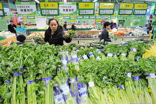 People select vegetable at a supermarket in Xingtai city, North China's Hebei province, Feb 17, 2016. (Photo/Xinhua)